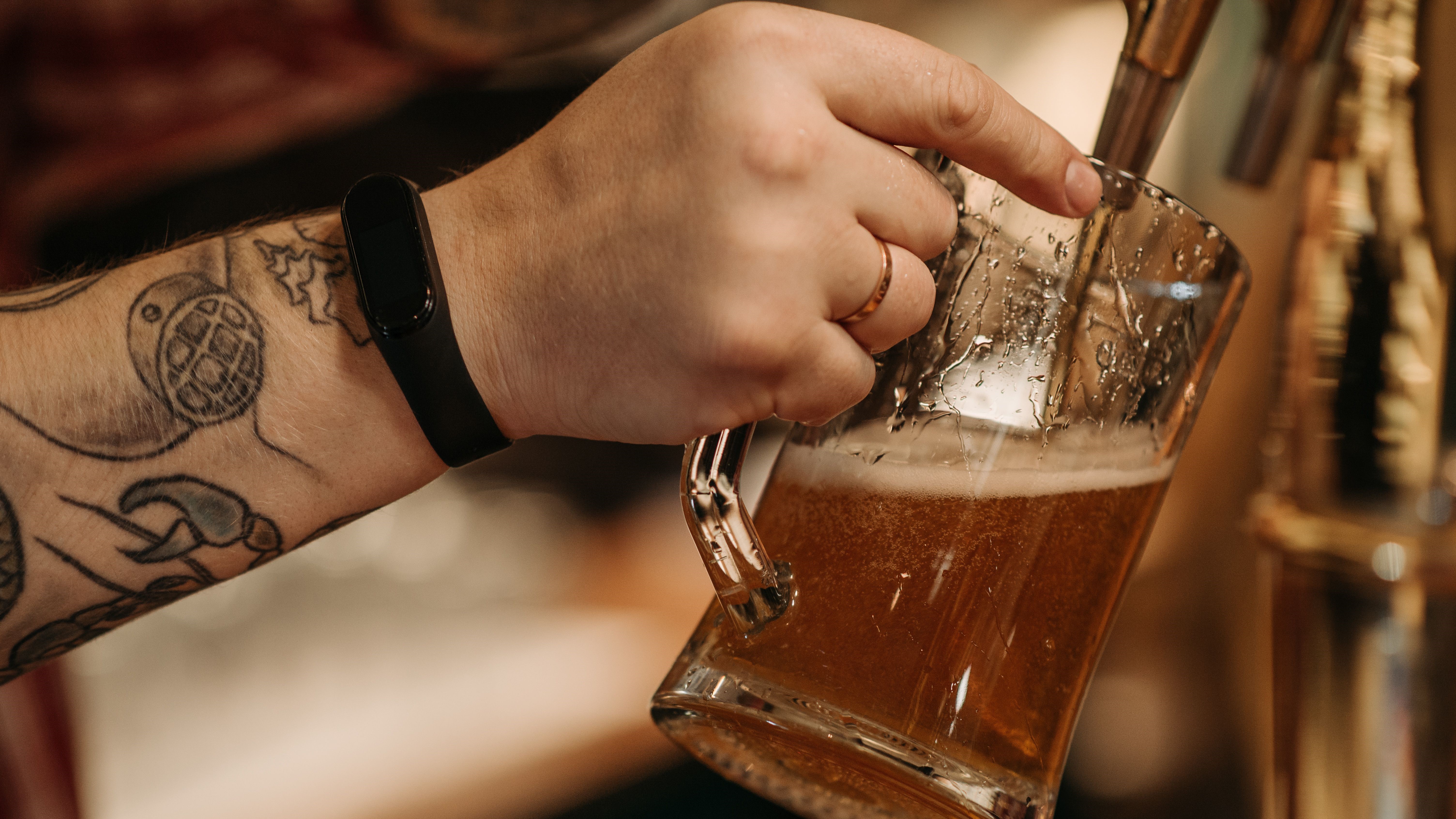 Copo de bebida alcoólica ao lado de cuidados com tatuagem nova
